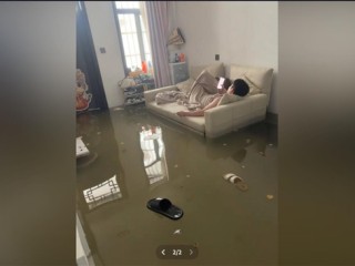 暴雨淹了家：夫妻俩1个玩手机1个补觉 太淡定了 ！